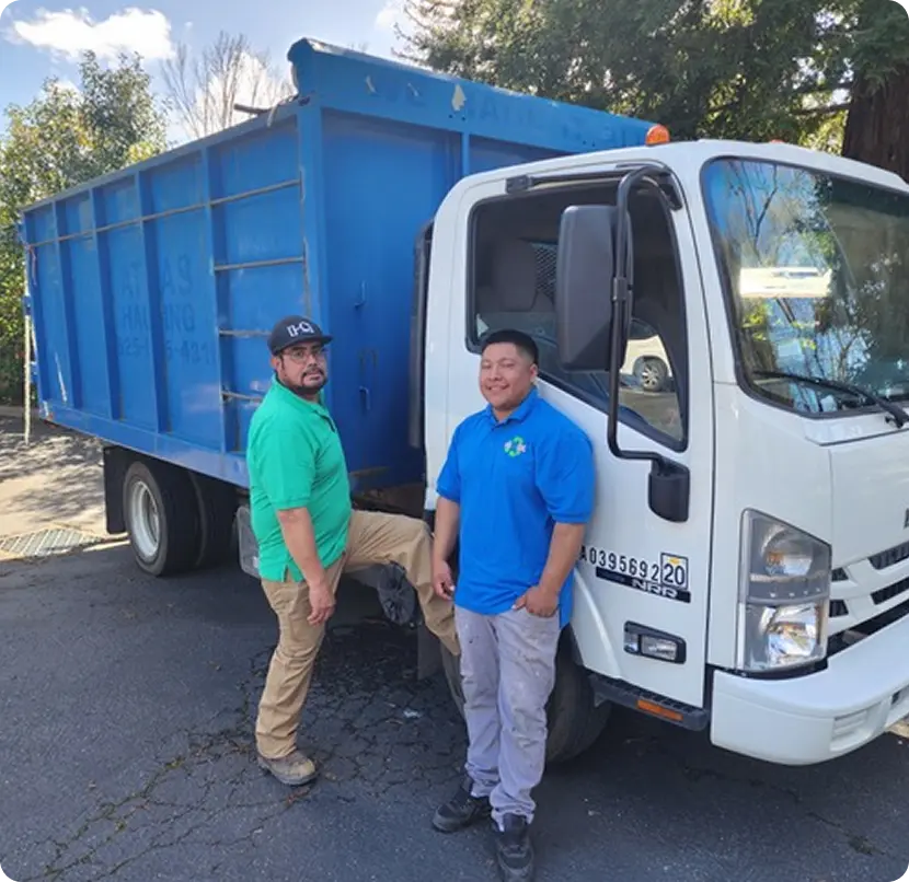 Two men stand beside a dump truck
