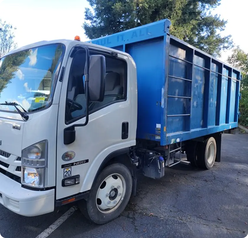 A white dump truck parked in a spacious parking lot