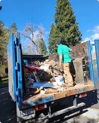 A man loading a truck with trash bags