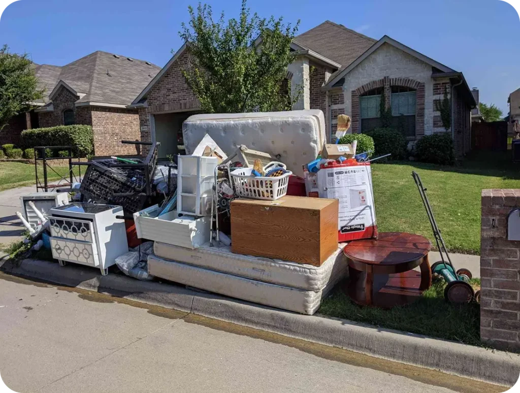 A disorganized pile of furniture and various items discarded on the side of a road.