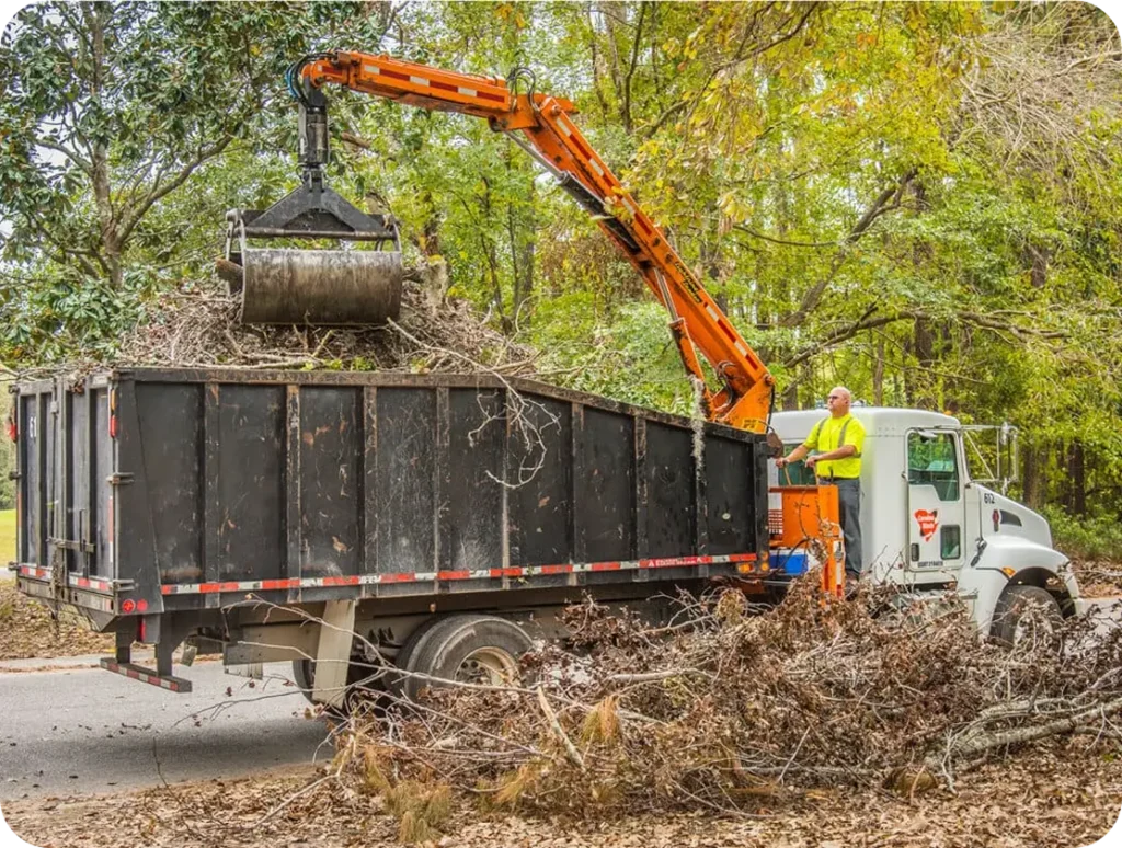 A man loading debris into a dump truck on a construction site